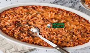 Johnny Marzetti Gurih Khas Amerika Serikat Johnny Marzetti dengan pasta, saus daging, dan keju leleh di piring saji