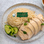 Khao Man Gai dengan ayam rebus dan saus jahe di piring saji