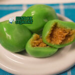 Kue Bugis ketan isi kelapa dibungkus daun pisang di piring saji
