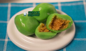 Kue Bugis Ketan Kelapa Manis Khas Indonesia Kue Bugis ketan isi kelapa dibungkus daun pisang di piring saji