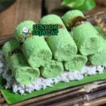 Kue Putu bambu hijau dengan gula merah kelapa di piring saji