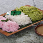 Kue Putu Mayang dengan saus santan kental di mangkuk saji