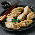 Mandu dengan pangsit goreng dan saus cocolan di piring saji