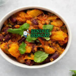 Matoke dengan pisang tumbuk dan saus kacang di piring saji