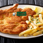 Argentine Milanesa daging goreng garing lemon fries salad di piring saji