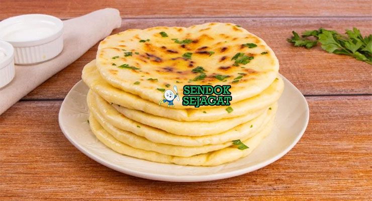 Naan Roti Pipih Gurih Khas India Naan roti pipih lembut gelembung ghee dengan curry di piring saji
