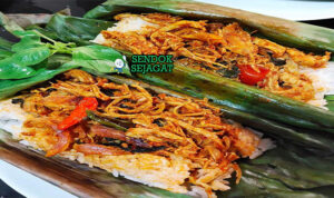 Nasi Bakar Ayam Suwir Harum Khas Jawa Tengah Nasi Bakar Ayam Suwir dengan daun pisang dan lalapan di piring saji