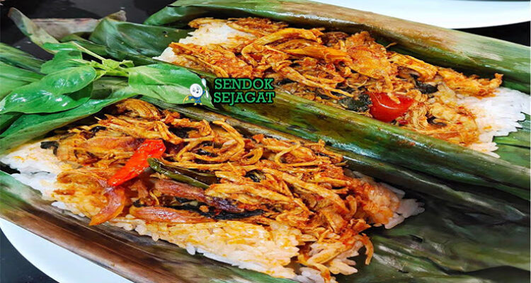 Nasi Bakar Ayam Suwir dengan daun pisang dan lalapan di piring saji