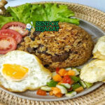 Nasi Goreng Kambing gurih daging cincang kecap dengan acar telur di mangkuk saji