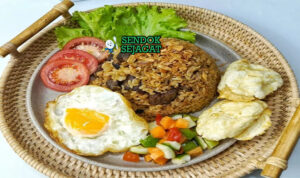 Nasi Goreng Kambing gurih daging cincang kecap dengan acar telur di mangkuk saji