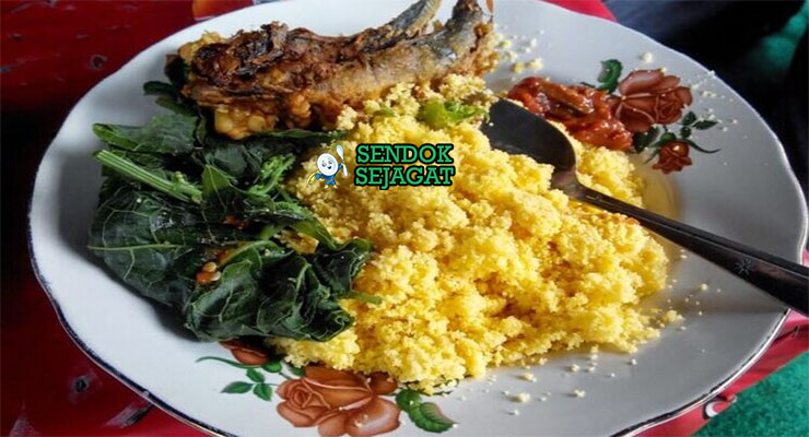 Nasi Jagung Campur Ikan Asap Khas Madura Nasi Jagung campur ikan asap dengan sambal dan kangkung di piring saji