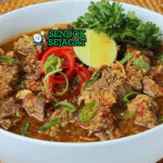 Pallubasa sup daging kelapa sangrai dengan nasi di mangkuk saji