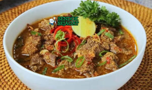 Pallubasa Sup Daging Kelapa Sangrai Khas Makassar Pallubasa sup daging kelapa sangrai dengan nasi di mangkuk saji