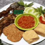 Pecel Lele dengan lele goreng dan sambal tomat di piring saji