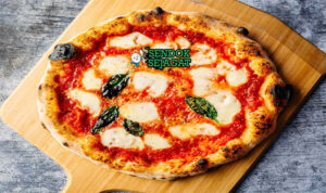 Pizza Margherita tipis gelembung mozzarella meleleh basil segar di piring saji