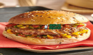 Pljeskavica Juicy Khas Balkan Pljeskavica burger daging dengan roti somun dan ajvar di piring saji