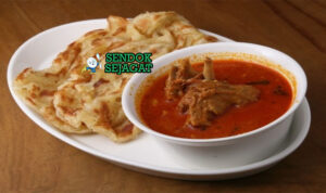 Roti Canai Flaky Gurih Khas Malaysia Roti Canai renyah lapis dengan saus kari ayam di piring saji