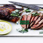 Saltbush Lamb Roast dengan domba panggang dan sayuran di piring saji