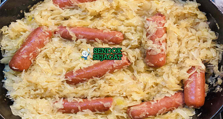 Sauerkraut kubis fermentasi dengan sosis di piring saji