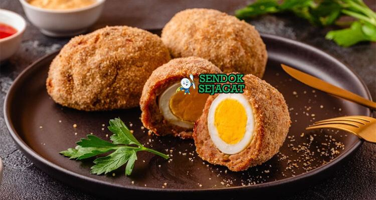 Scotch Egg potong dua telur runny daging renyah di piring saji