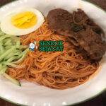 Bibim Guksu mie dingin sayur daging saus gochujang di mangkuk saji