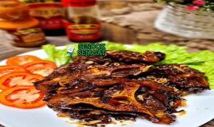 Buntut Bakar potongan gosong kecap manis wangi dengan sambal lalapan di piring saji