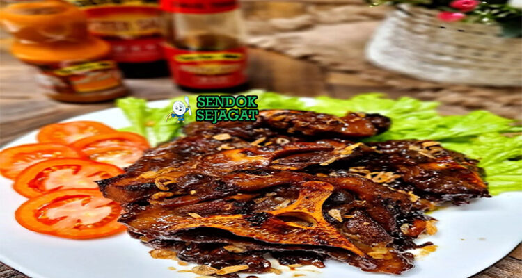 Buntut Bakar potongan gosong kecap manis wangi dengan sambal lalapan di piring saji