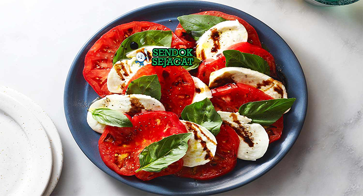 Caprese Salad tumpuk tomat mozzarella basil balsamic di piring saji