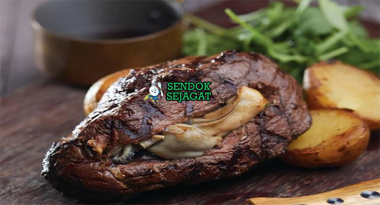 Carpetbag Steak iris isi tiram mentega parsley lemon di piring saji