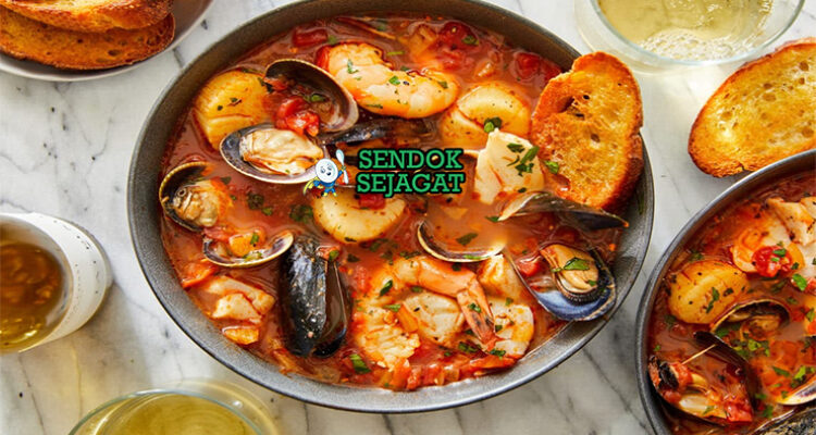 Cioppino seafood stew kerang udang kepiting kuah tomat roti sourdough di mangkuk besar