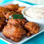 Conch Fritters golden renyah potongan conch remoulade lime di piring anyaman pantai