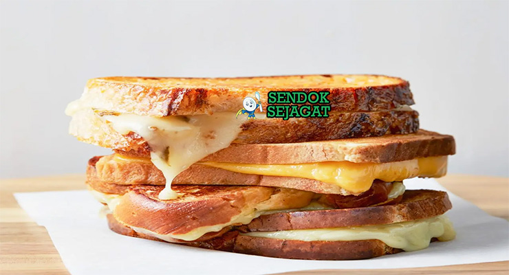Grilled Cheese Sandwich roti garing keju meleleh potong diagonal dengan sup tomat