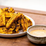 Grilled Corn Ribs jagung potong belah panggang paprika mentega lime di piring saji