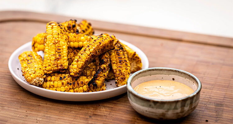 Grilled Corn Ribs jagung potong belah panggang paprika mentega lime di piring saji