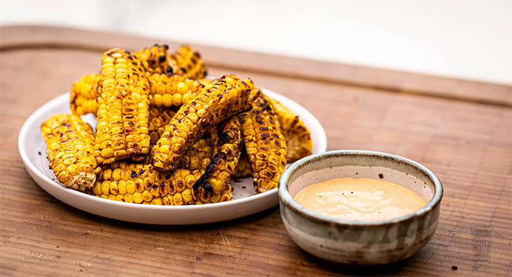 Grilled Corn Ribs jagung potong belah panggang paprika mentega lime di piring saji