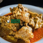 Gulai Kambing kuah santan kuning pekat daging empuk bawang goreng emping di mangkuk saji