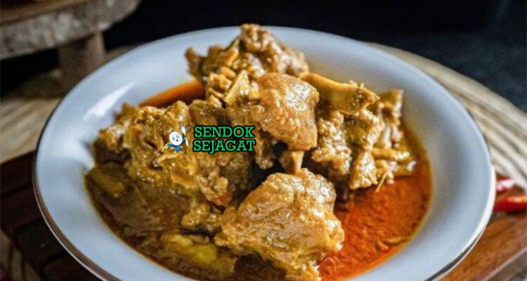 Gulai Kambing kuah santan kuning pekat daging empuk bawang goreng emping di mangkuk saji