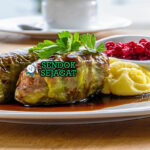 Kåldolmar Kubis Gulung isi daging saus krim lingonberry di piring saji
