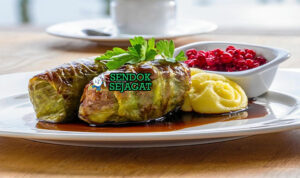 Kåldolmar Kubis Gulung isi daging saus krim lingonberry di piring saji