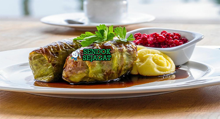 Kåldolmar Kubis Gulung isi daging saus krim lingonberry di piring saji