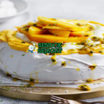 Mango Pavlova tinggi meringue putih whipped cream mangga irisan passionfruit toasted coconut mint