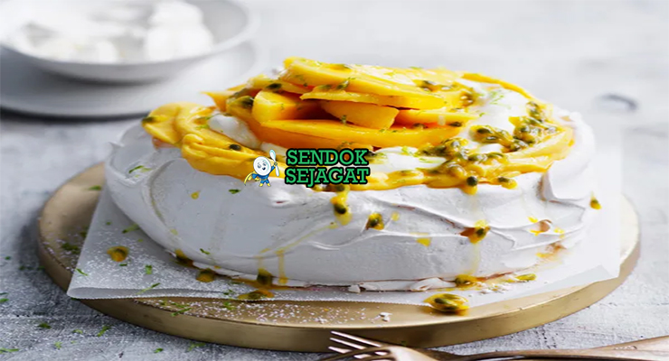 Mango Pavlova tinggi meringue putih whipped cream mangga irisan passionfruit toasted coconut mint