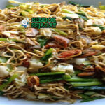 Mie Tek Tek goreng kerang telur wortel bawang goreng di piring saji
