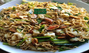 Mie Tek Tek goreng kerang telur wortel bawang goreng di piring saji