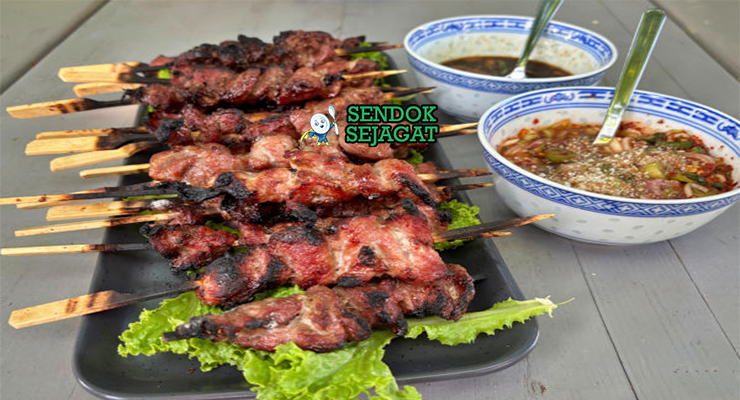 Moo Ping tusuk babi karamel mengkilap sticky rice nam jim jaew timun di daun pisang