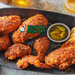 Nashville Hot Chicken ayam golden pedas saus cayenne roti acar di piring saji