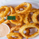 Onion Rings golden garing tumpuk tinggi garlic aioli tomato sauce di piring pub Australia