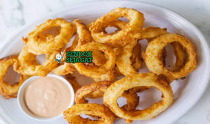 Onion Rings Kriuk Beer Batter Khas Aussie Pub Onion Rings golden garing tumpuk tinggi garlic aioli tomato sauce di piring pub Australia