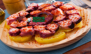 Pulpo a la Gallega Asap Manis Khas Galicia Pulpo a la Gallega iris tipis gurita empuk pimentón merah olive oil mengkilap kentang cachelos di piring kayu