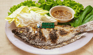 Pla Pao ikan gurame bakar garam daun pisang saus jeruk nipis di piring saji